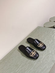 FLAT MULES IN BLACK SMOOTH CALFSKIN GOLD BUCKLE