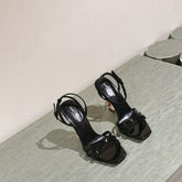 YSL 25S HIGH-HEEL SANDALS 100 MM IN BLACK GLOSSY LAMBSKIN WITH YSL LOGO HEEL DESIGN IN GOLD