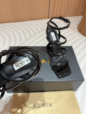 ALAIA THREE-STRAPS HIGH HEEL SANDALS IN BLACK PATENT LAMBSKIN