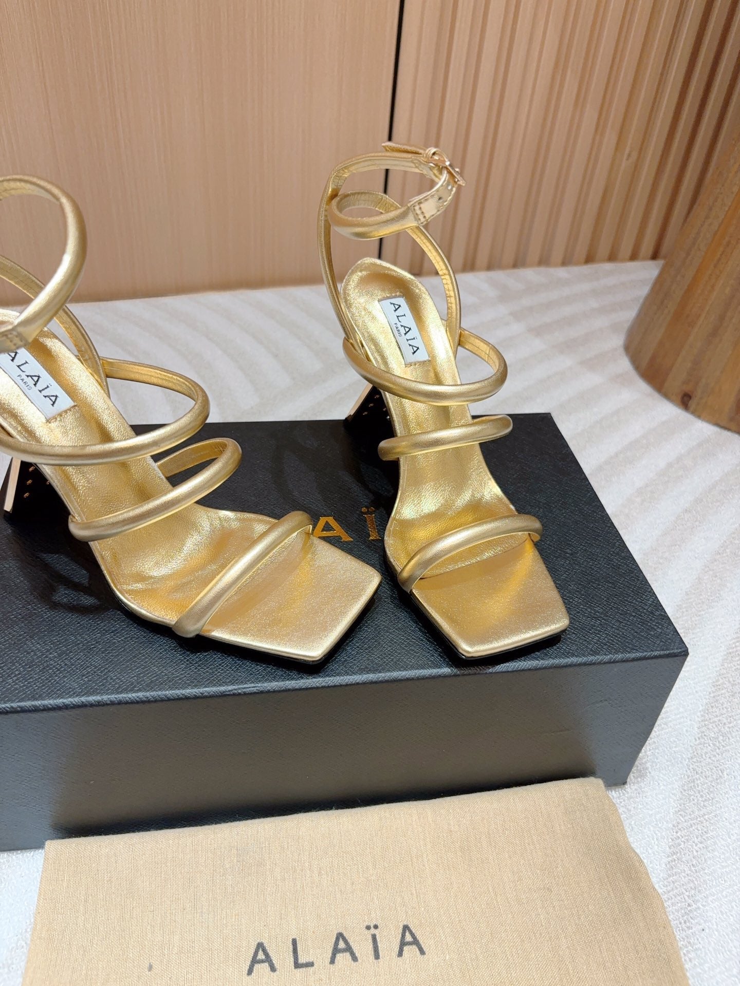 ALAIA THREE-STRAPS HIGH HEEL SANDALS IN GOLDEN PATENT LAMBSKIN
