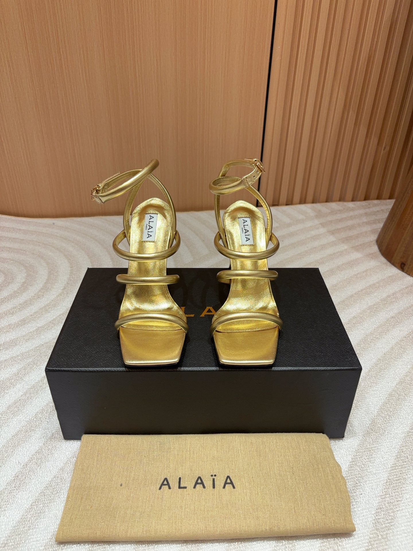 ALAIA THREE-STRAPS HIGH HEEL SANDALS IN GOLDEN PATENT LAMBSKIN