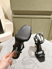 YSL 25S HIGH-HEEL SANDALS 100 MM IN BLACK SATIN WITH YSL LOGO HEEL DESIGN IN GOLD