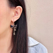 CHANEL 26S DOUBLE C LOGO BLACK ENAMEL BOW DANGLE EARRINGS WITH CHAIN CHARMS IN GOLD METAL 629178