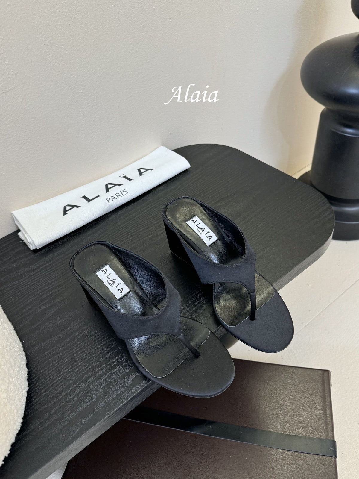 ALAIA WEDGE THONG SANDALS 25S IN BLACK SATIN
