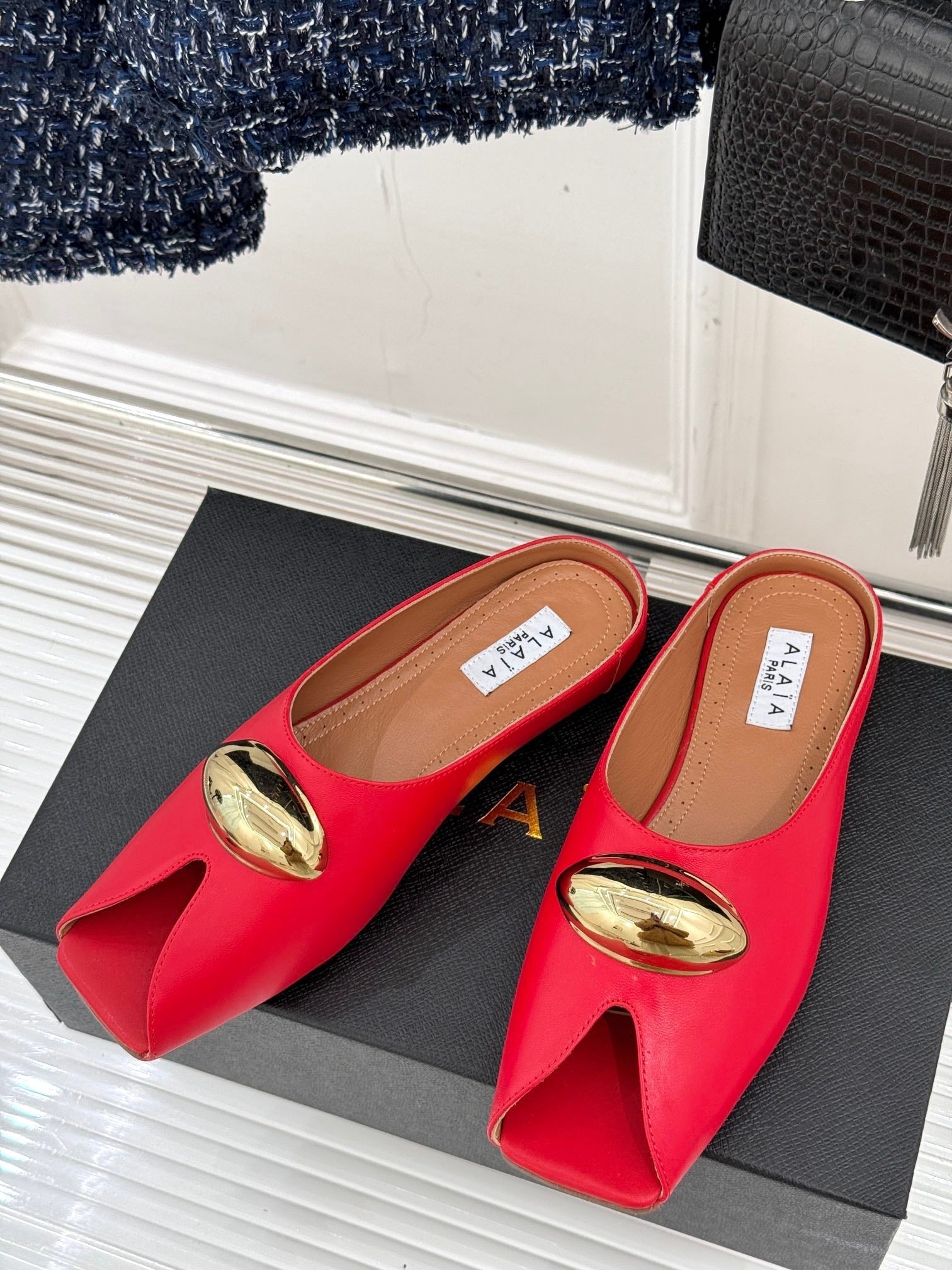 ALAIA FLAT MULE IN CRIMSON RED LAMBSKIN WITH GOLD HARDWARE