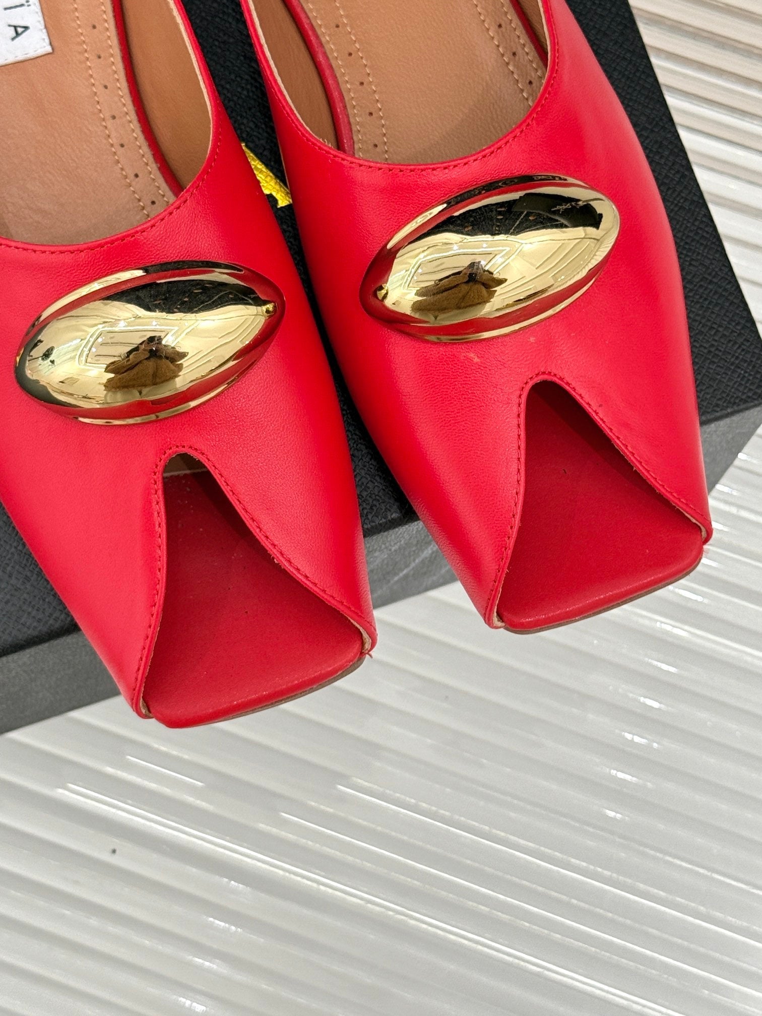 ALAIA FLAT MULE IN CRIMSON RED LAMBSKIN WITH GOLD HARDWARE