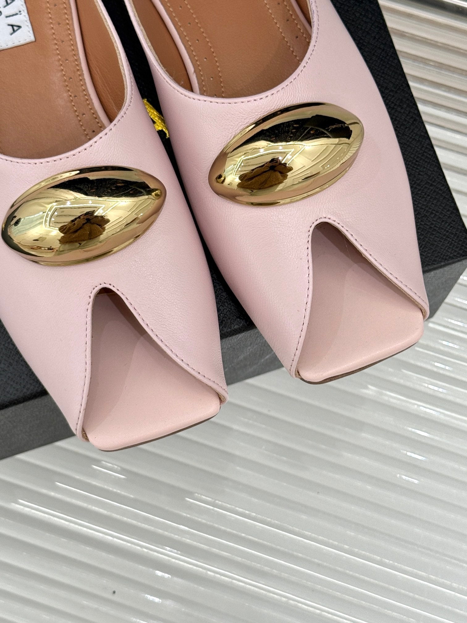 ALAIA FLAT MULE IN LIGHT PINK LAMBSKIN WITH GOLD HARDWARE