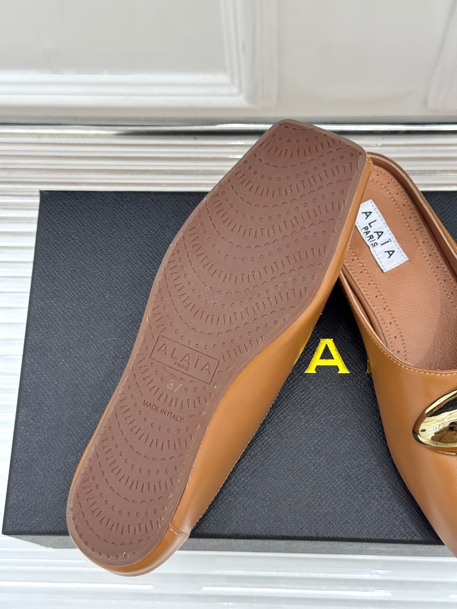 ALAIA FLAT MULE IN BRONZE BROWN LAMBSKIN WITH GOLD HARDWARE