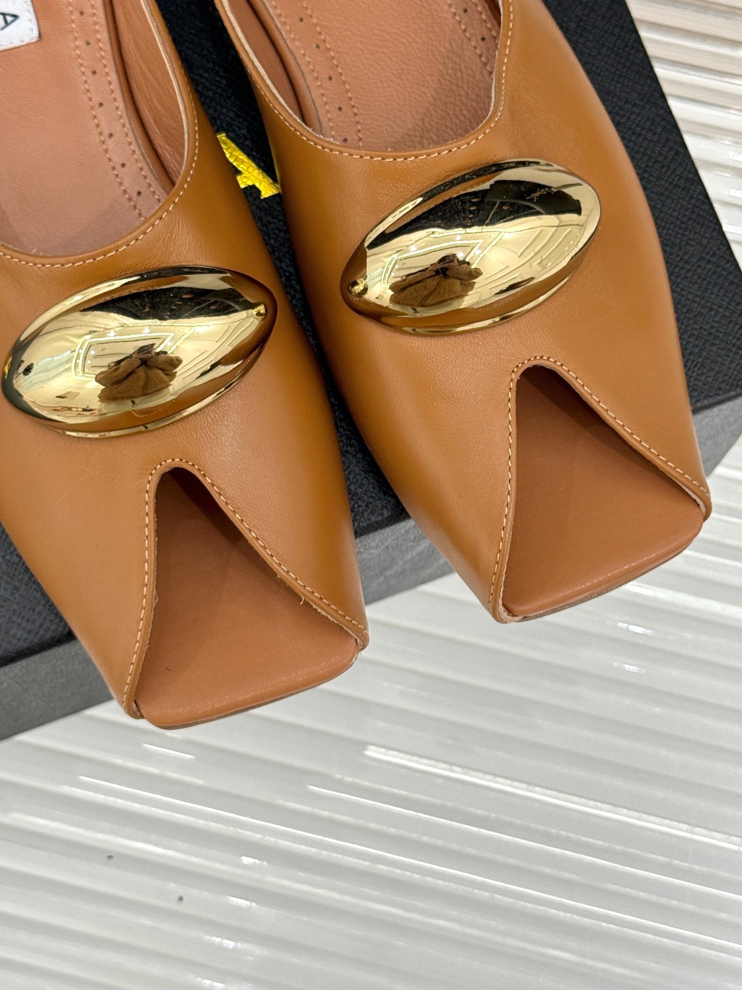 ALAIA FLAT MULE IN BRONZE BROWN LAMBSKIN WITH GOLD HARDWARE