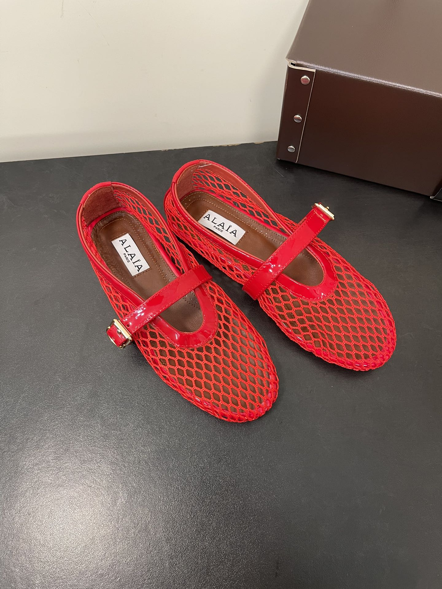 ALAIA BALLET FLATS IN CHERRY RED MESH FISHNET