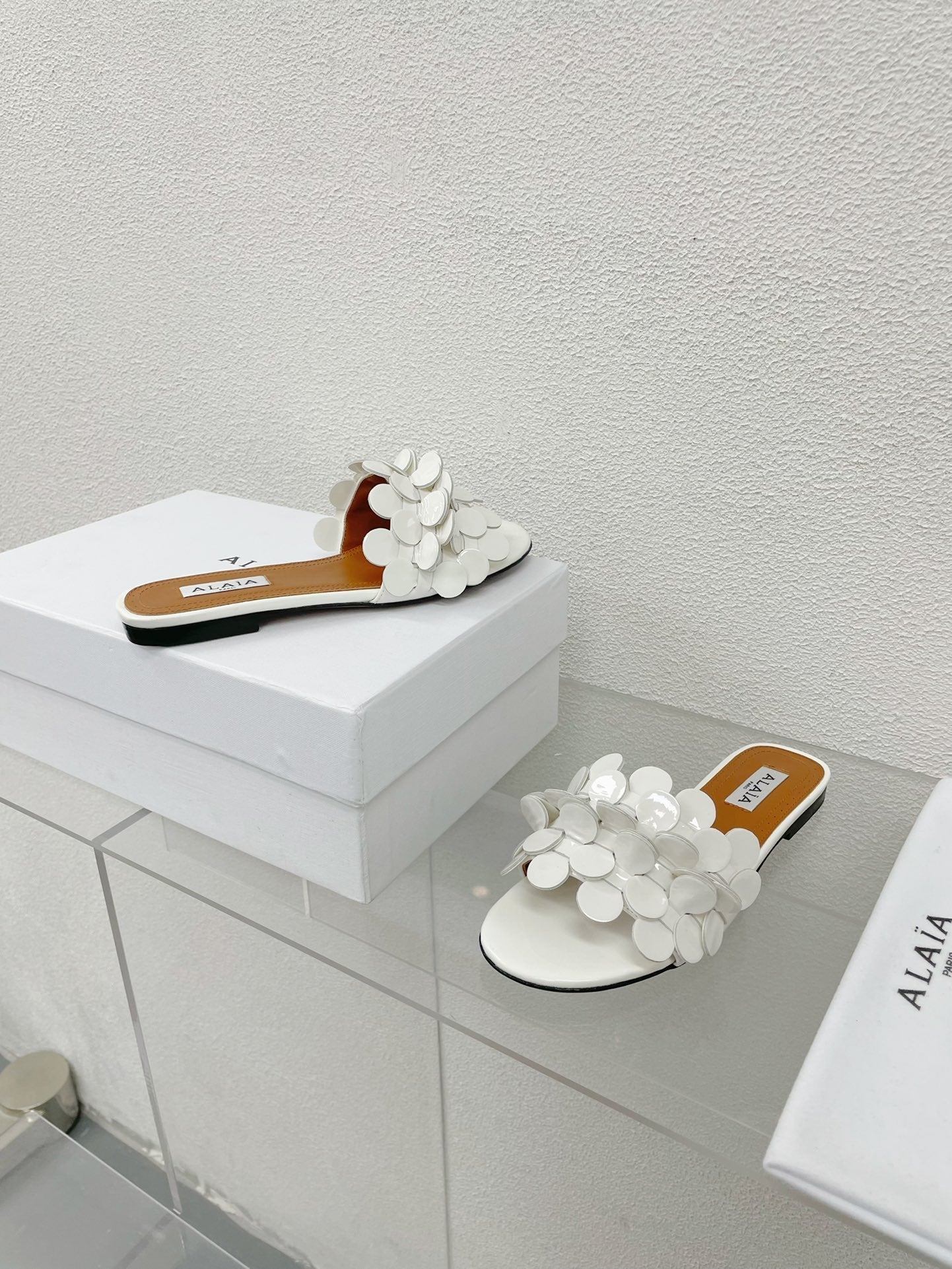 ALAIA FLAT MULE IN WHITE GLOSSY LAMBSKIN