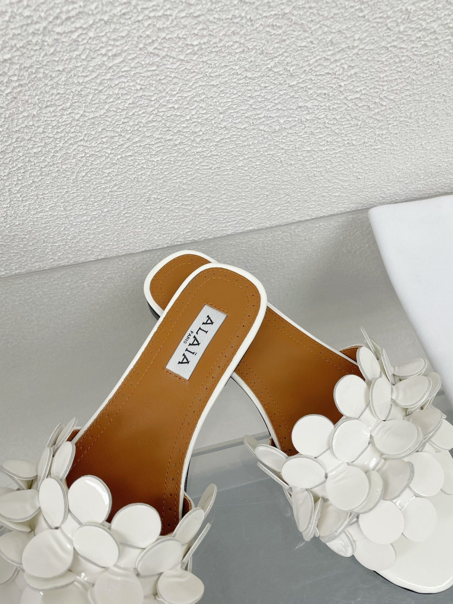 ALAIA FLAT MULE IN WHITE GLOSSY LAMBSKIN