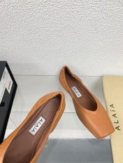 ALAIA BALLET FLATS IN COPPER BROWN CALFSKIN