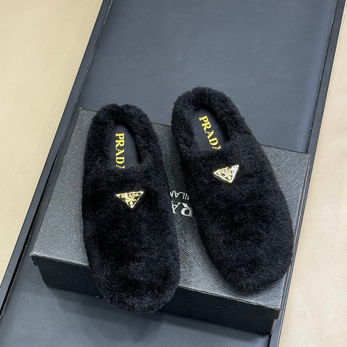 PRADA 25S CLOGS IN BLACK SHEARLING
