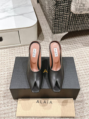 ALAIA SPIKE JEWEL MULES IN BLACK CALFSKIN
