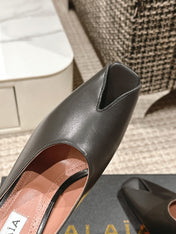 ALAIA SPIKE JEWEL MULES IN BLACK CALFSKIN