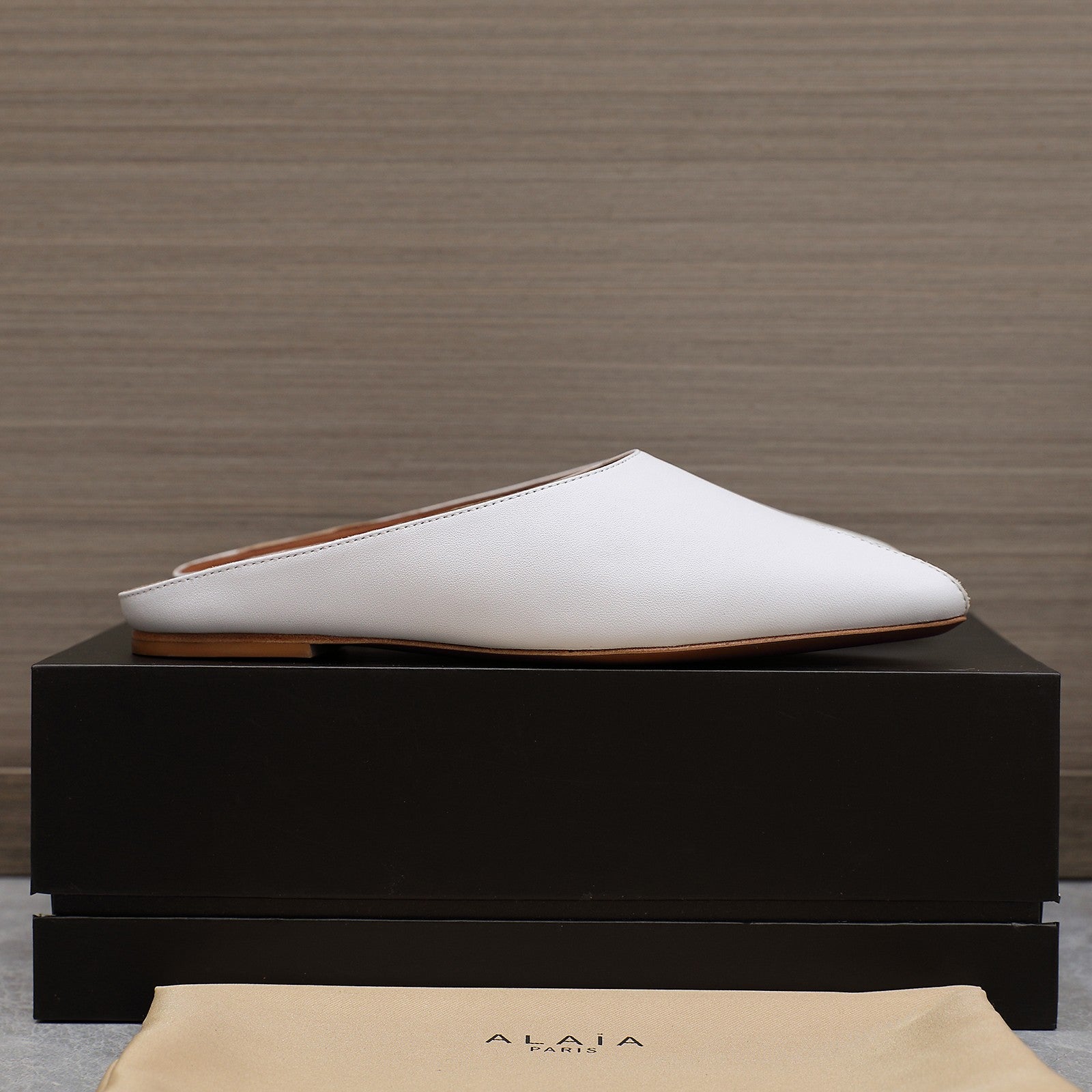 ALAIA FLAT MULE IN WHITE LAMBSKIN