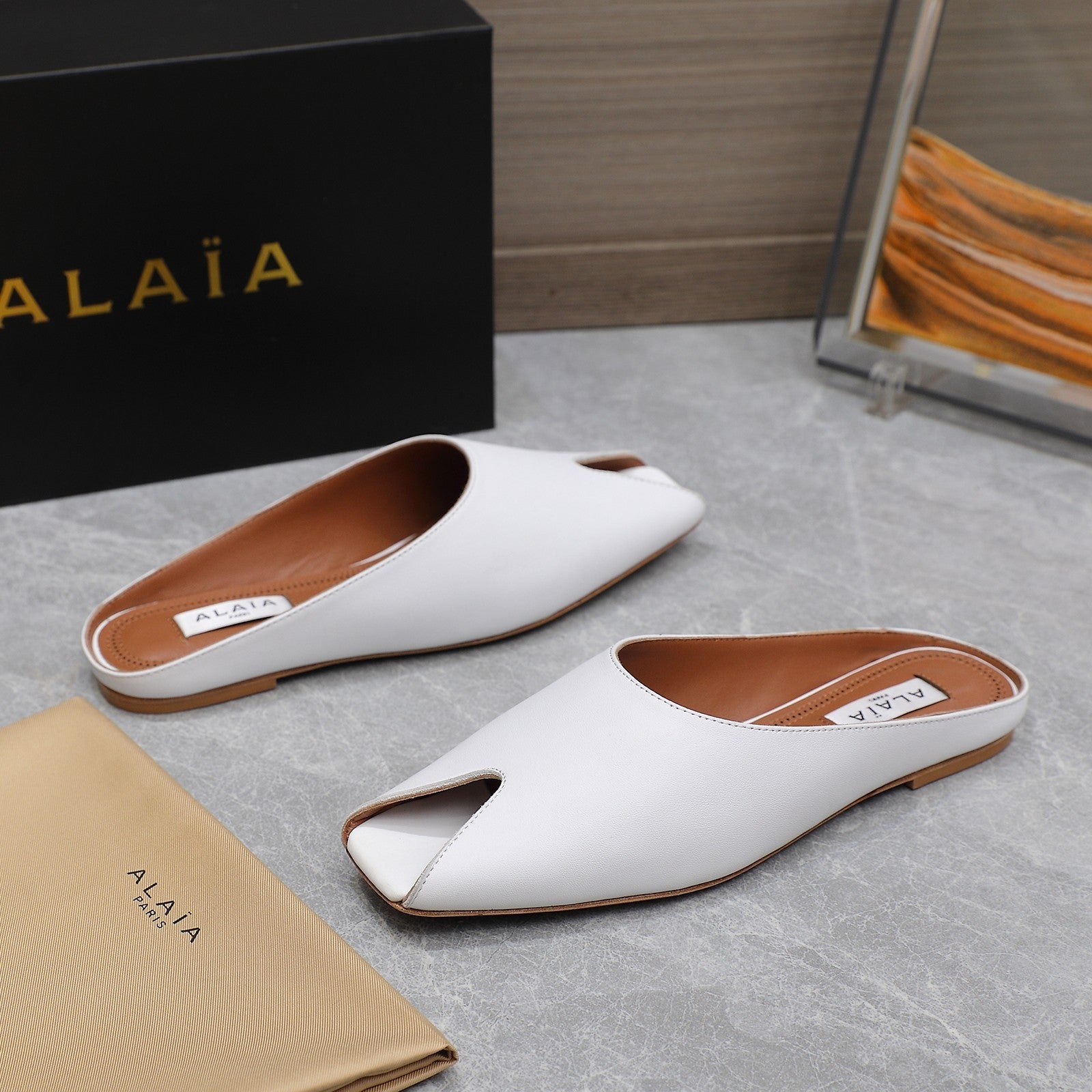 ALAIA FLAT MULE IN WHITE LAMBSKIN