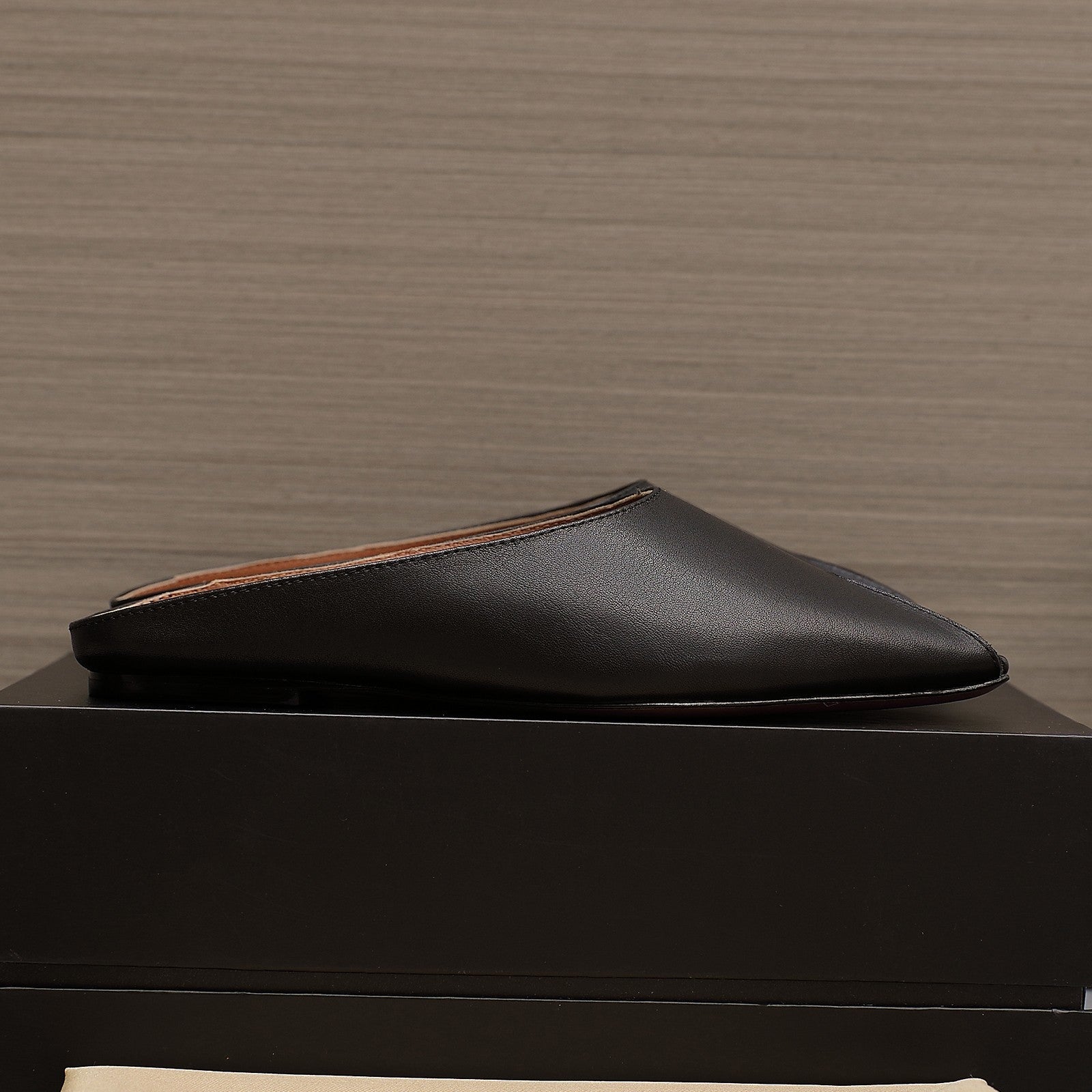 ALAIA FLAT MULE IN BLACK LAMBSKIN