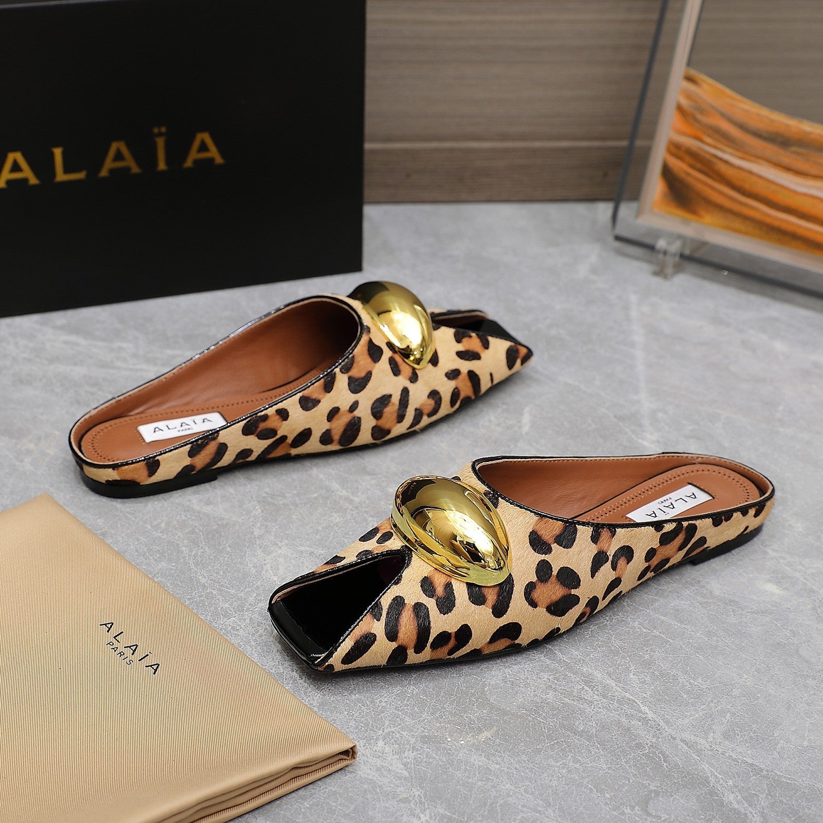 ALAIA FLAT MULE IN LEOPARD LAMBSKIN WITH GOLD HARDWARE
