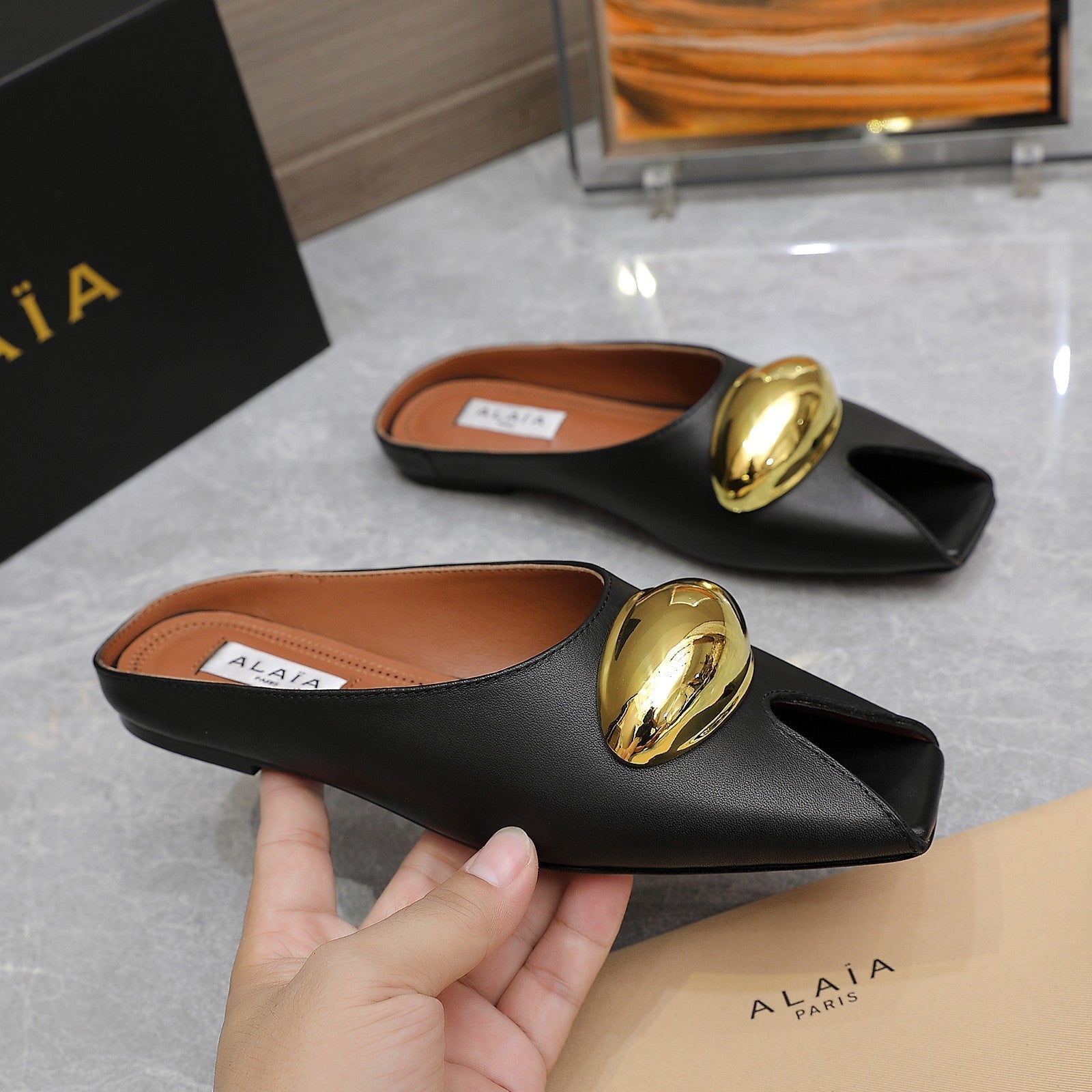 ALAIA FLAT MULE IN BLACK LAMBSKIN WITH GOLD HARDWARE